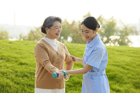 女哑铃户外年轻女护工指导老人康复背景