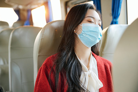 在大巴上戴口罩睡着的女性背景图片
