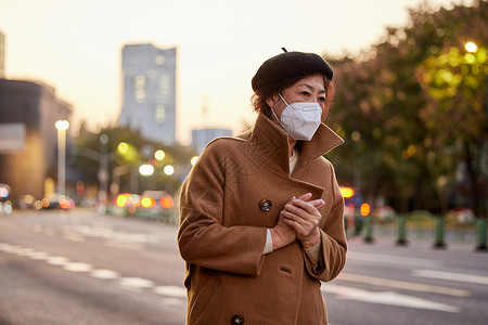 戴口罩的中老年女性路边等车图片