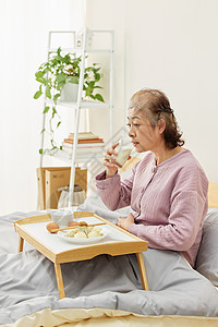 卧床吃早餐的奶奶背景图片
