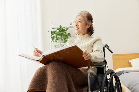 坐轮椅的居家老奶奶翻看相册图片