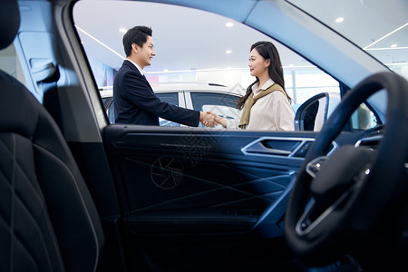 女顾客与汽车销售握手成交高清图片