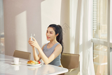美女早晨坐在餐桌吃早饭背景图片