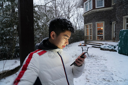 微信下雪素材男孩在院子里玩手机背景