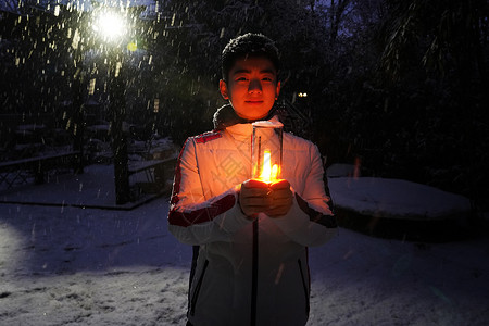 雪景下小萝莉男孩在院子里手捧小台灯背景