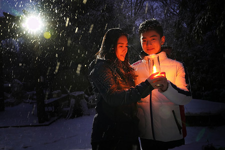 雪和明亮枫树男孩和妈妈在院子里手捧小台灯背景