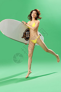 抱腿兴奋的青年女人抱着冲浪板背景