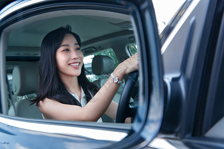 侧视镜里驾车的青年女人高清图片