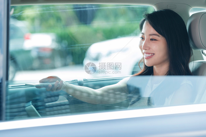 坐在汽车里的快乐青年女人图片