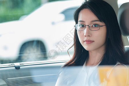 透过窗户往外表现积极坐在汽车里的漂亮青年女人背景