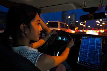 夜晚开车的青年女人看屏幕导航图片