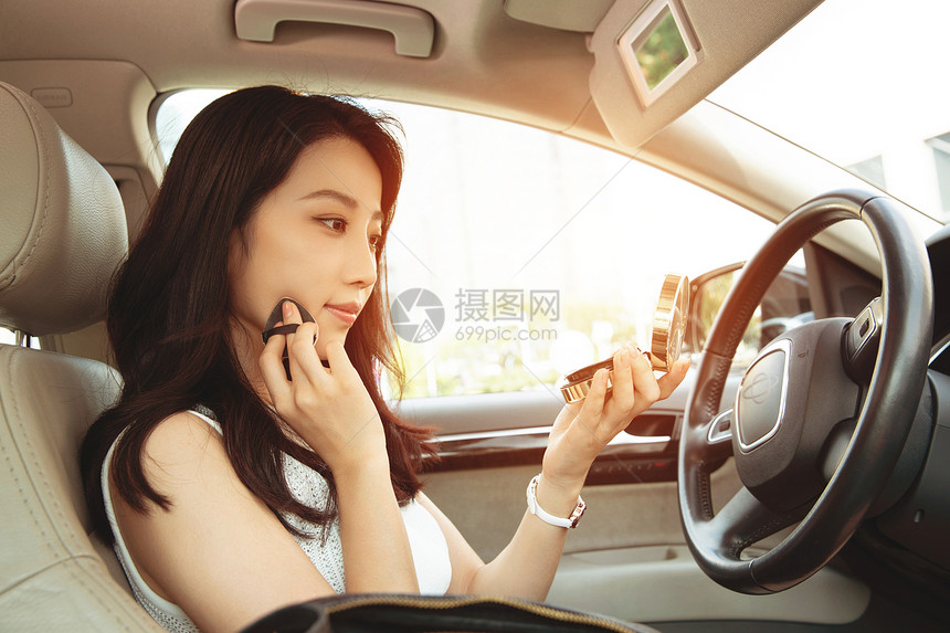 青年女人坐在车里化妆图片