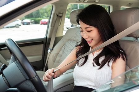 驾车前系安全带的青年女人图片