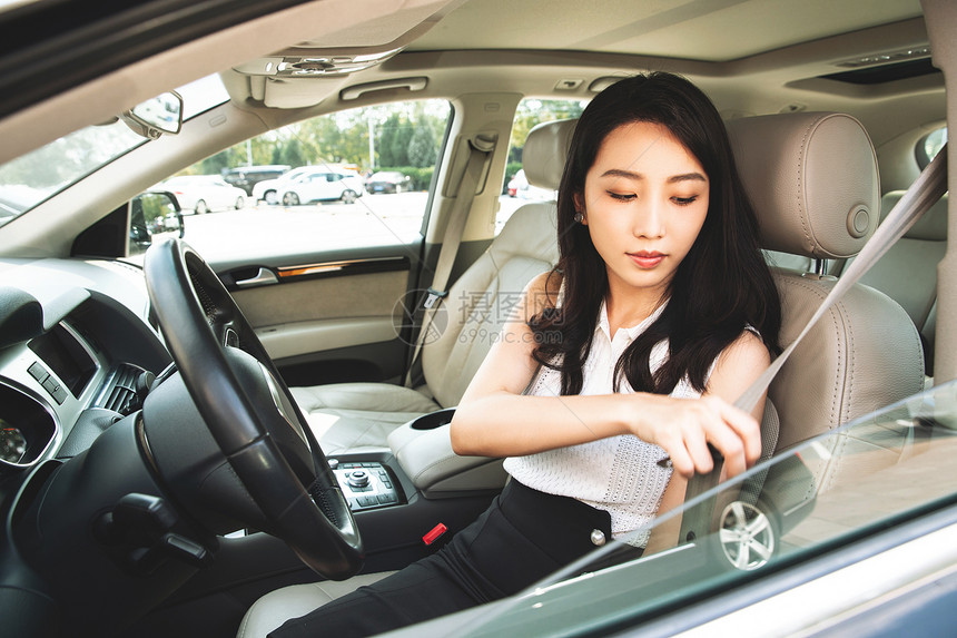 驾车前系安全带的青年女人图片