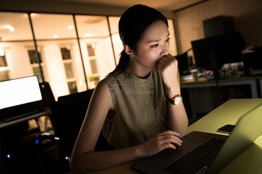 在办公室加班的年轻女士图片