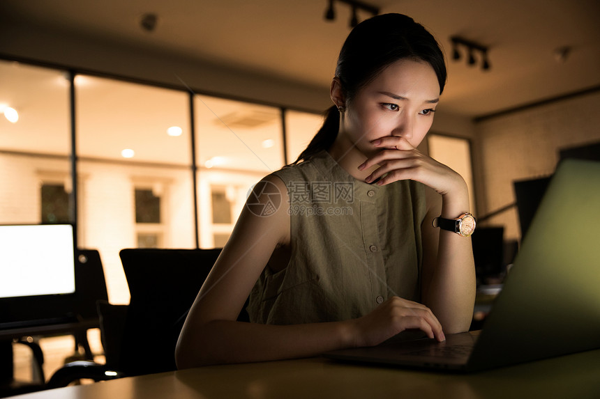 在办公室加班的年轻女士图片