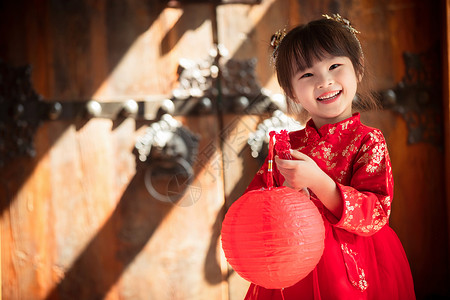 木制的漂亮的可爱的小女孩拿着红灯笼背景