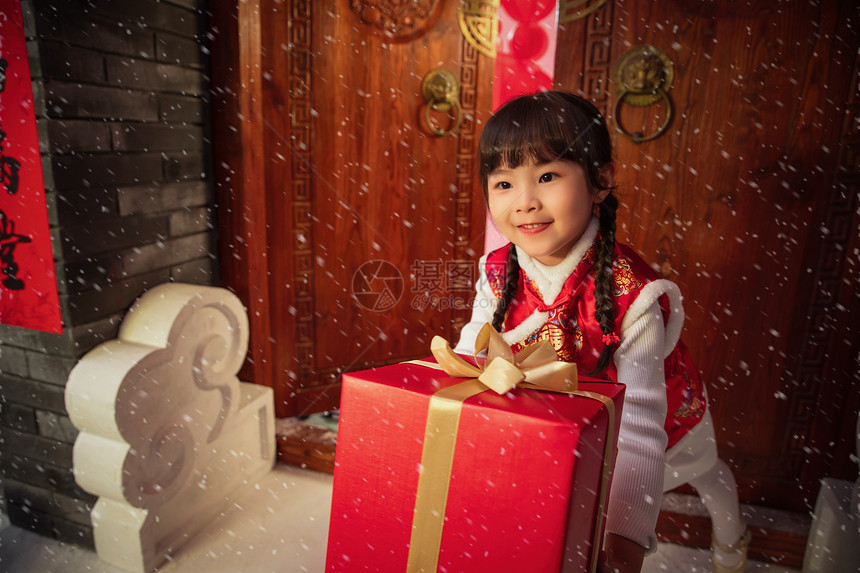 拜年的可爱小女孩拿着礼品盒图片