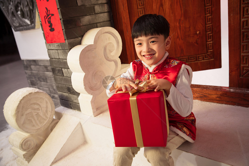 可爱的小男孩抱着礼品盒图片