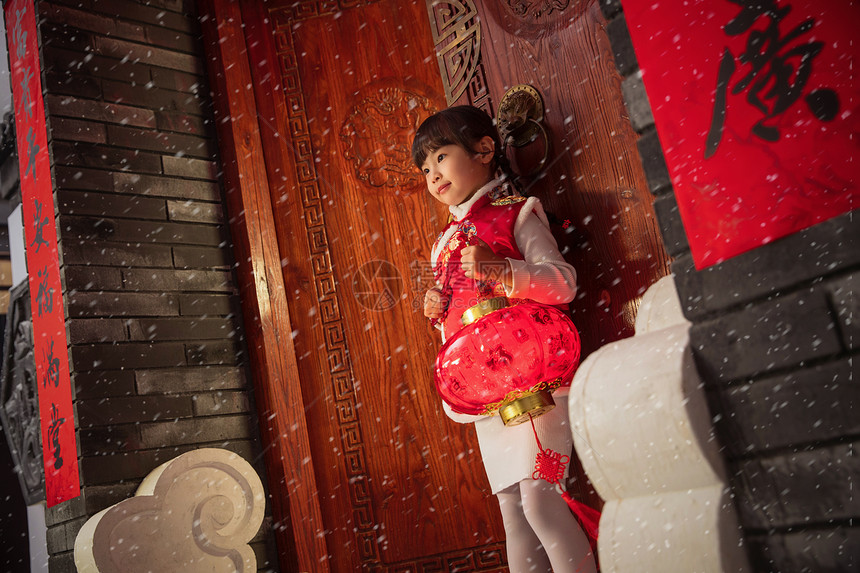 雪中小女孩手提红灯笼玩耍图片