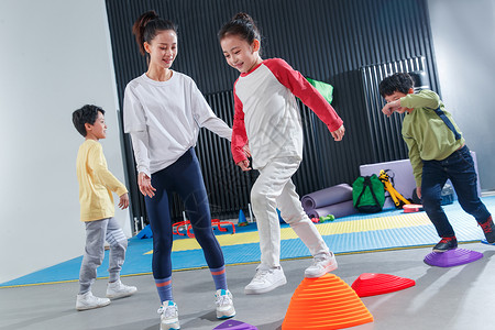 女孩在健身房儿童在教练的指导下进行体能训练背景