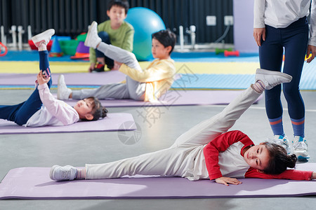 地面前景儿童在教练的指导下进行体能训练背景