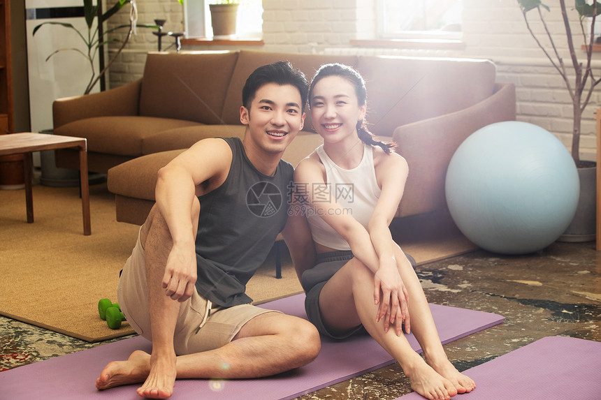 青年夫妇在家健身中场休息图片