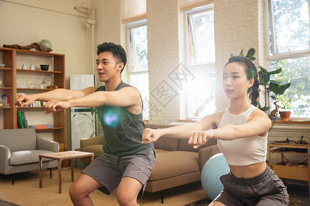 瑜珈球青年夫妇在家锻炼身体背景