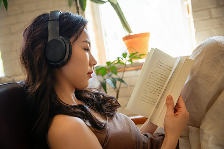年轻女人在家听音乐看书图片