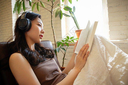 年轻女人在家听音乐看书图片