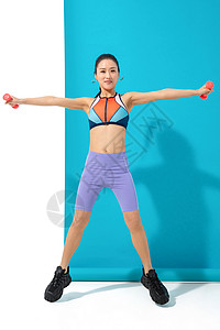 年轻女人举哑铃锻炼身体高清图片