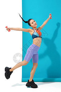 年轻女人举哑铃锻炼身体高清图片