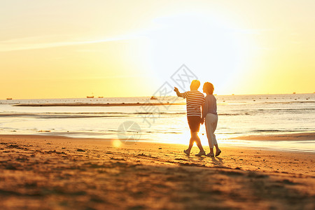 关爱海洋老年夫妇在海边散步背景