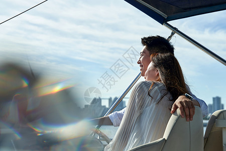 浪漫的青年夫妇乘坐游艇出海高清图片