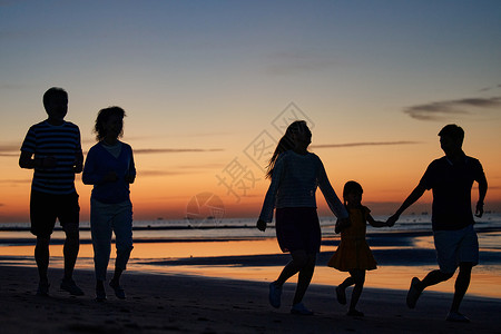 跑剪影在海边度假的快乐家庭背景