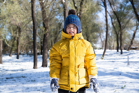 快乐的小男孩在雪地里玩耍图片