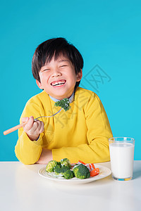 拿着叉子男孩快乐的小男孩吃蔬菜背景