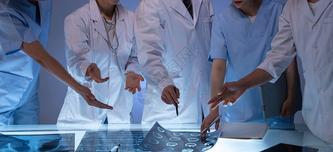 中间医疗用品医务工作者用手指着X光片讨论研究背景