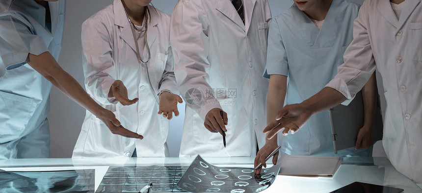 医务工作者用手指着X光片讨论研究图片