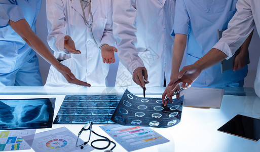 手指着平板电脑医务工作者用手指着X光片讨论研究背景