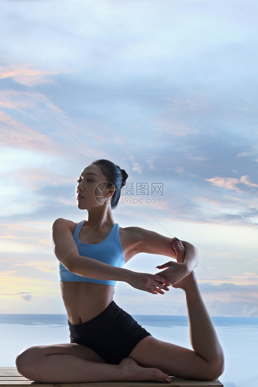 年轻女人在水面上练习瑜伽图片