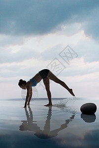 瑜珈球年轻女人在水面上练习瑜伽背景