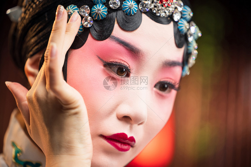 京剧女演员对着镜子佩戴首饰图片