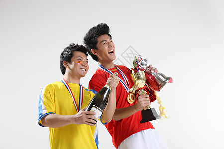 现代荣誉两个东方男运动员手拿奖杯背景