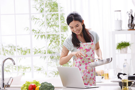 年轻女人在厨房做饭图片