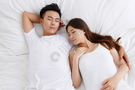青年夫妇在卧室的床上睡觉图片