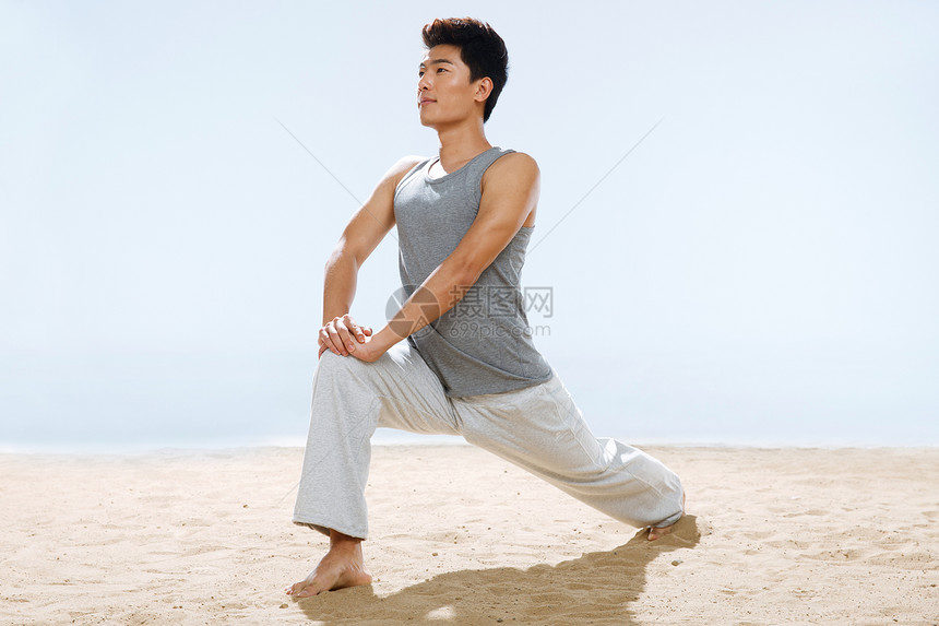 海边做瑜伽的青年男人图片