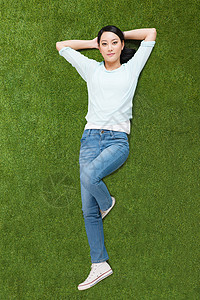 一个青年女人仰卧在草地上图片