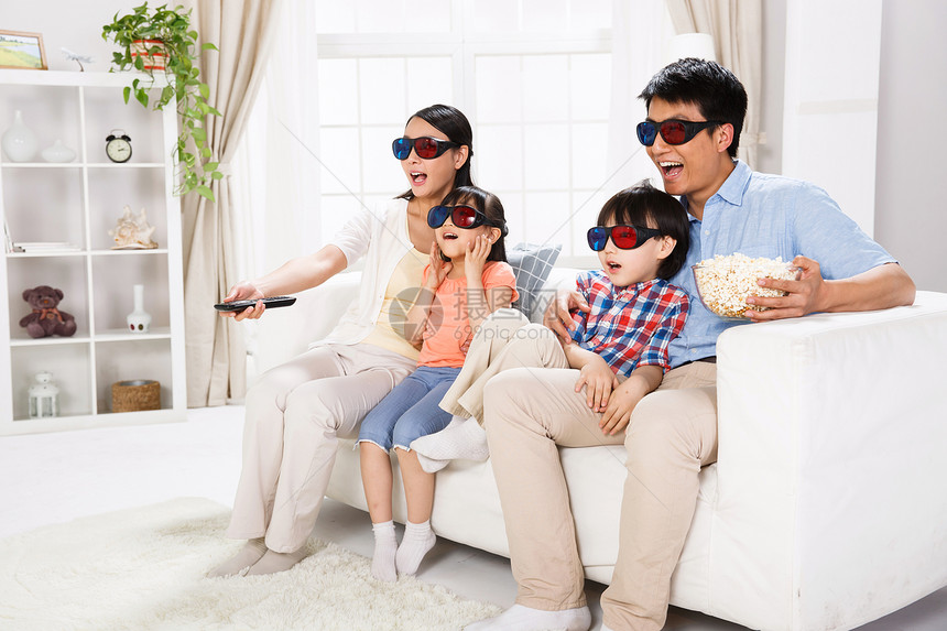 东方家庭戴着3D眼镜坐在沙发上图片
