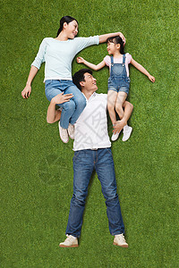 欢乐的一家三口仰卧在草地上图片